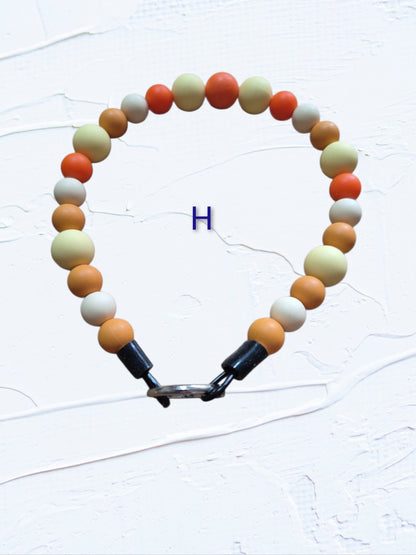 15 inch silicone beaded dog collar Colour H – orange, cream and tan silicone beads with silver O-ring clasp, handmade in Canada