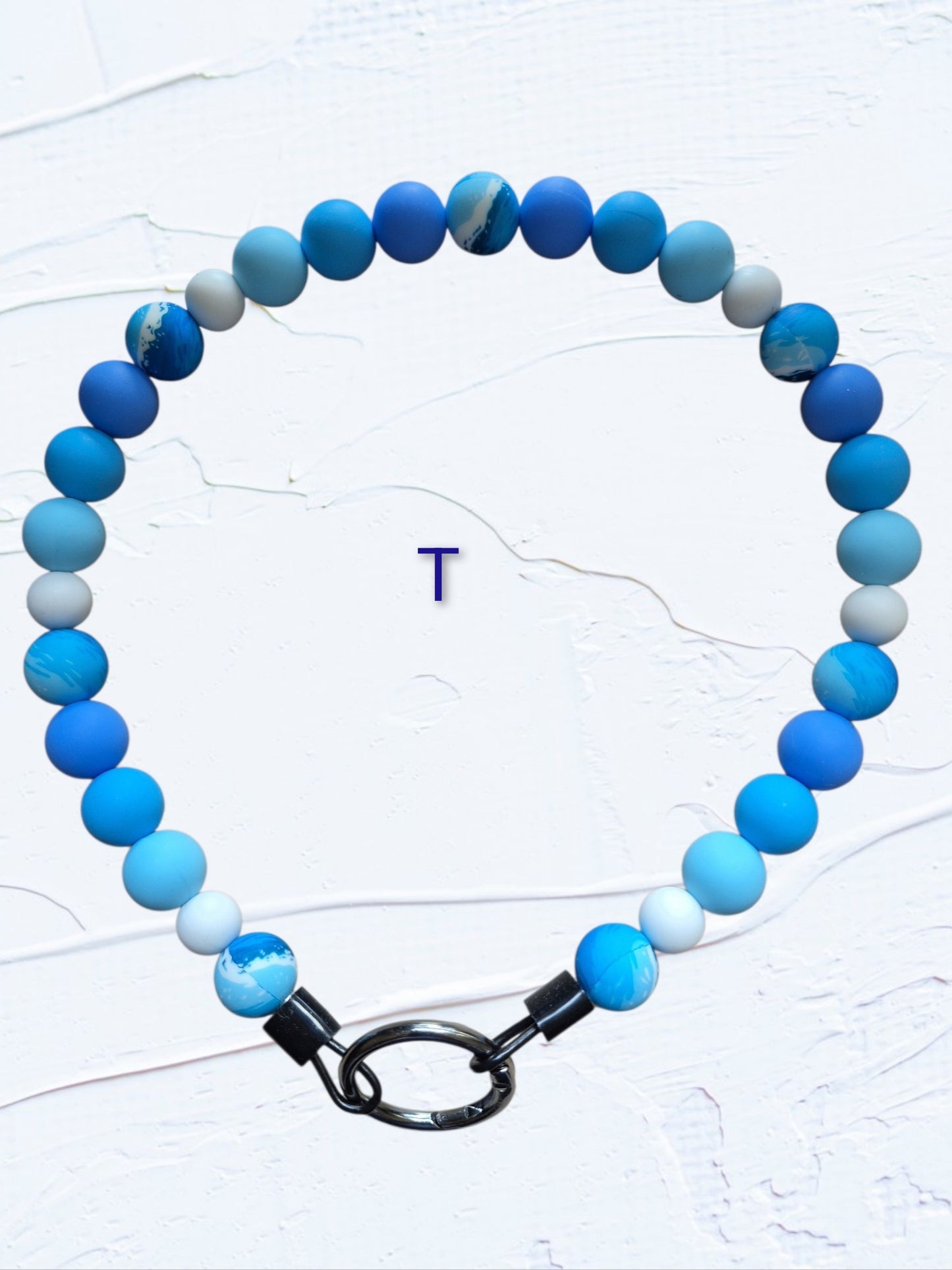 obalt blue, sky blue, light blue and white beads with marbled blue accent beads and black O-ring clasp