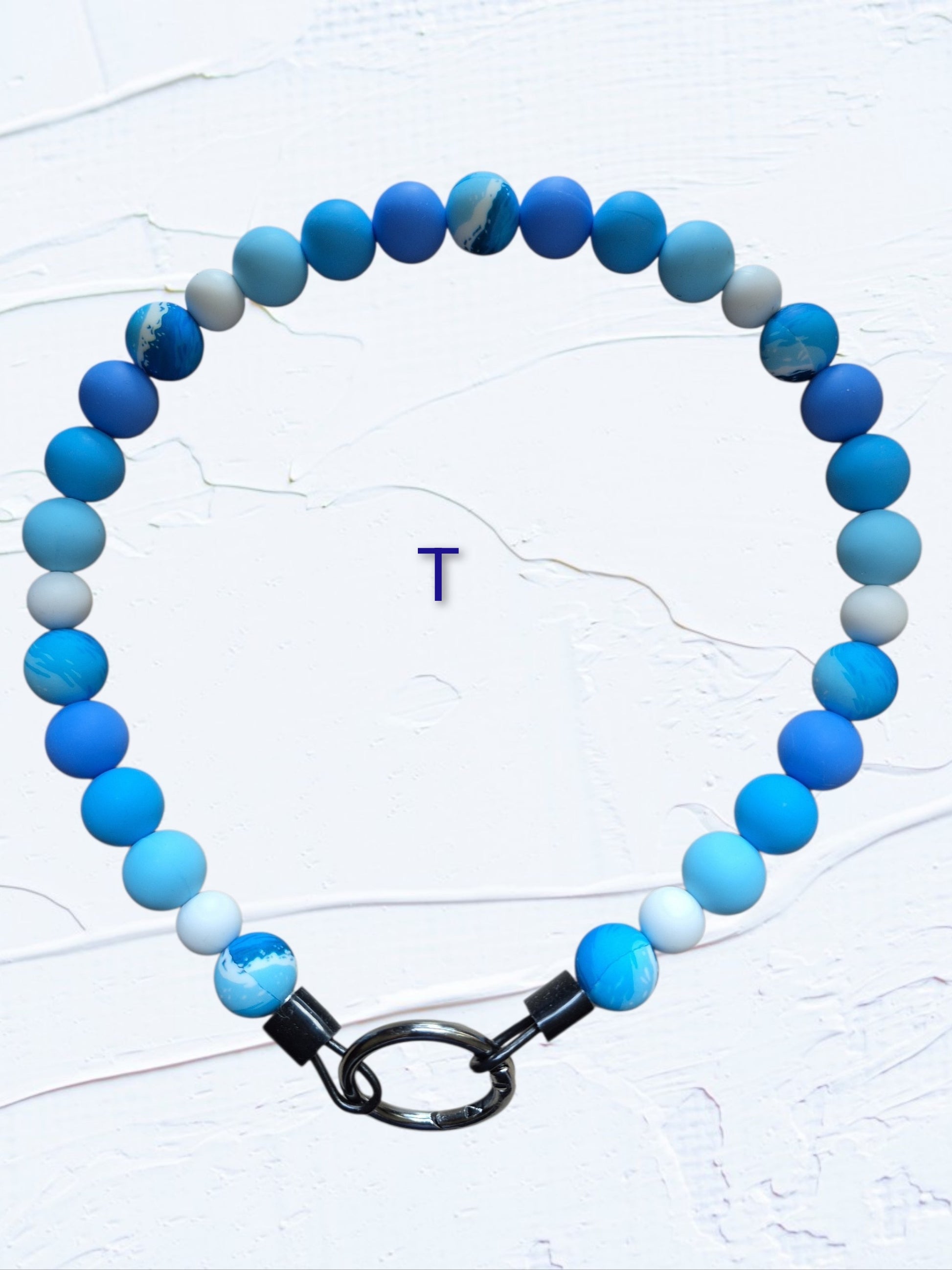 obalt blue, sky blue, light blue and white beads with marbled blue accent beads and black O-ring clasp