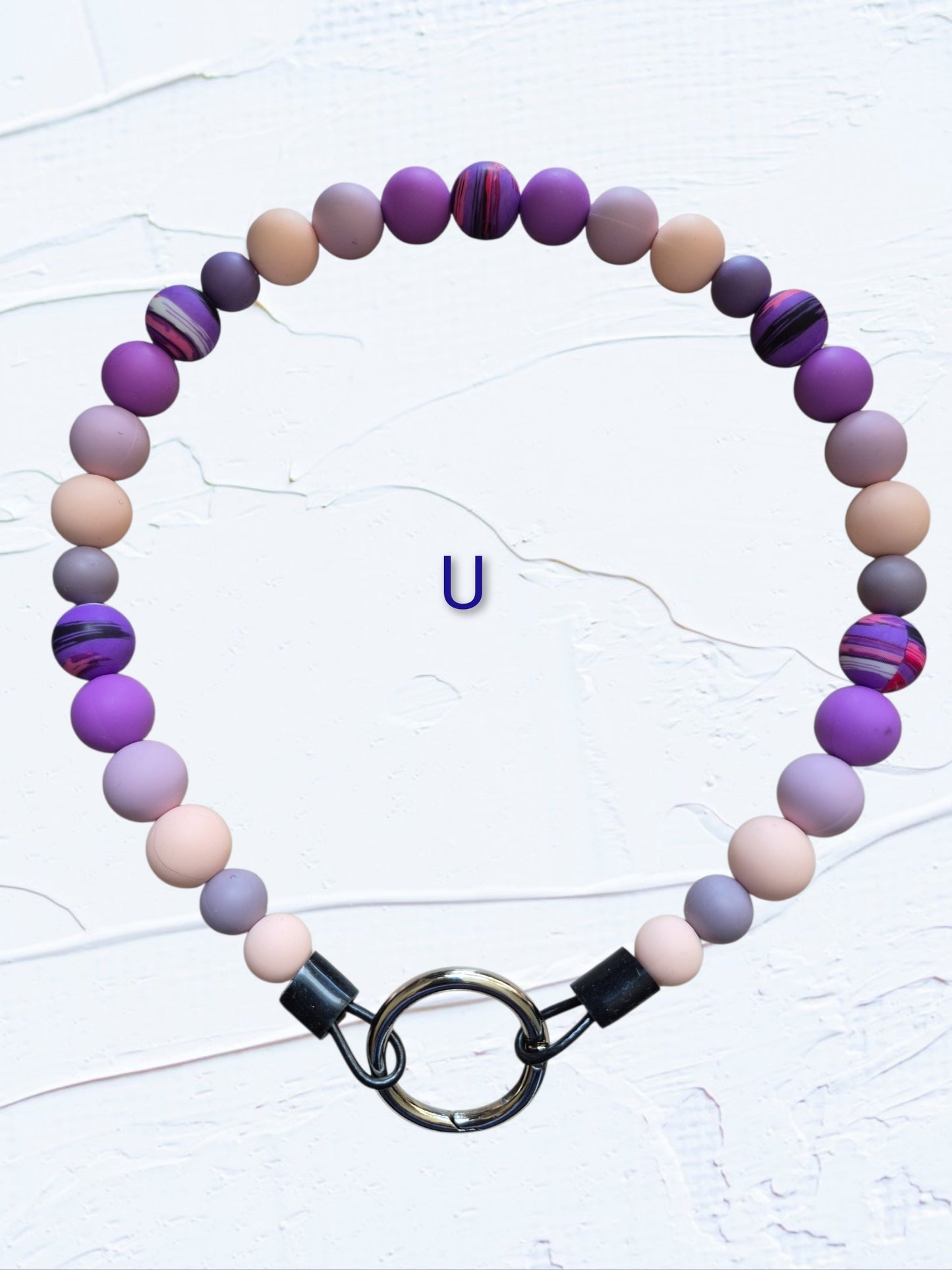 purple, lavender, beige and grey beads with purple marbled accent beads and black O-ring clasp