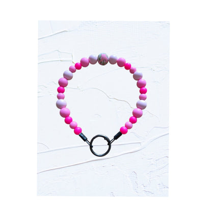 Beaded bracelet with pink and purple beads on a white background